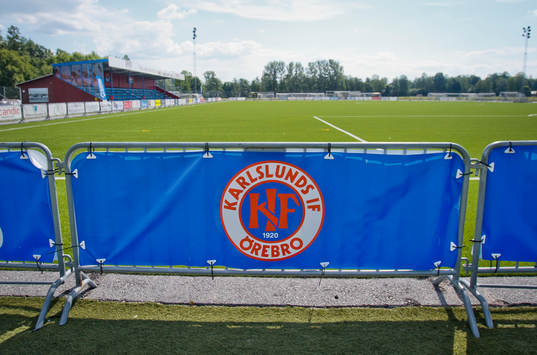 Karlsunds logotyp med planen i bakgrunden