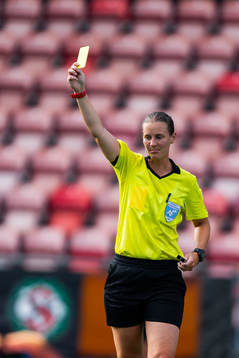 Domare Lovisa Johansson delar ut ett gult kort