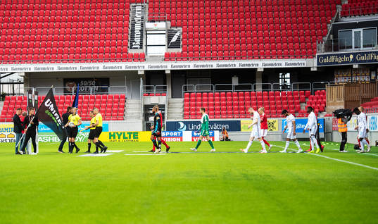 Spelarna marscherar in på arenan med Unibets flagga i