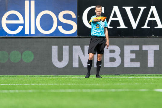 En assisterande domare vinkar för offside