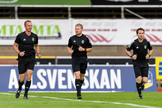 Domare Fredrik Klitte (mitten) före fotbollsmatchen i