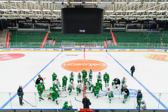 Spelarna samlas framför tränare Cam Abbott