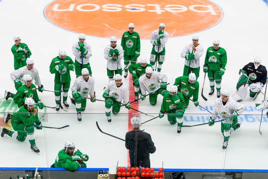 Spelarna samlas framför tränare Cam Abbott