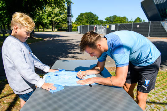 Eric Larsson skriver autografer