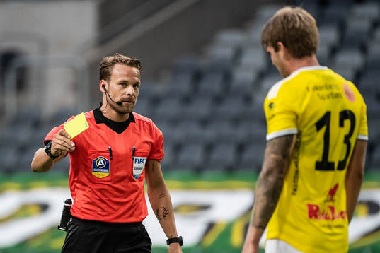 Domare Kristoffer Karlsson delar ut ett gult kort