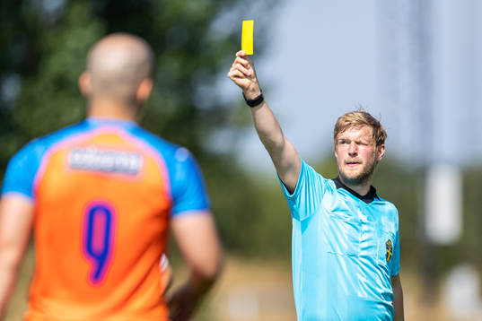 Domare Henrik Persson visar gult kort