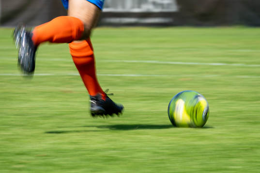 En fotbollsspelare springer med bollen