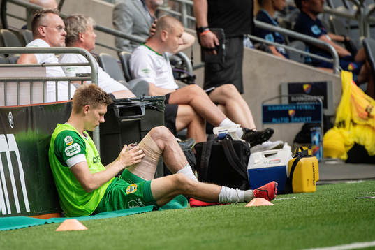 Hammarbys Aron Johansson sitter skadad vid sidan av planen