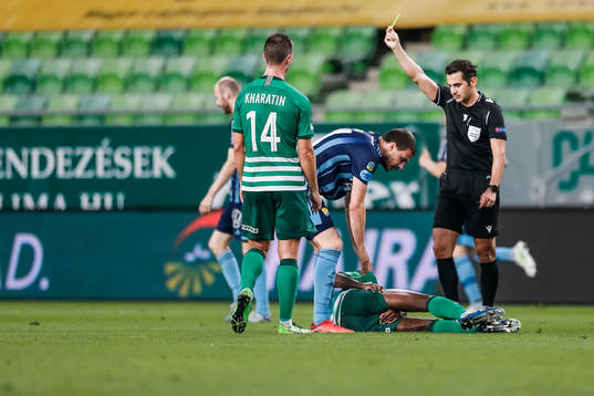 Referee Fedayi San shows a yellow card to Erik Berg of