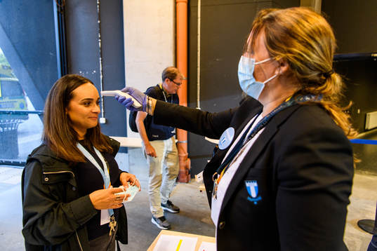 Staff check temperature of arriving media