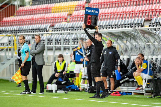 Fjärde domaren Robin Albertsson håller upp en skylt som