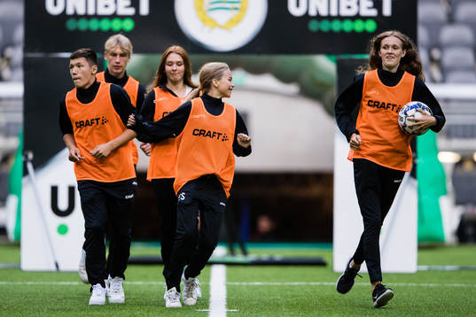 Bollflickor och bollpojkar innan fotbollsmatchen i