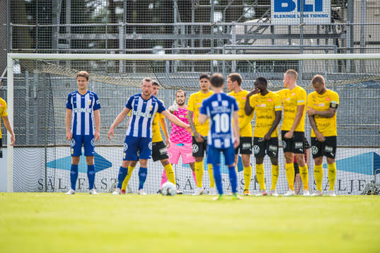 Mjällbys målvakt Carl-Johan Eriksson dirigerar muren vid
