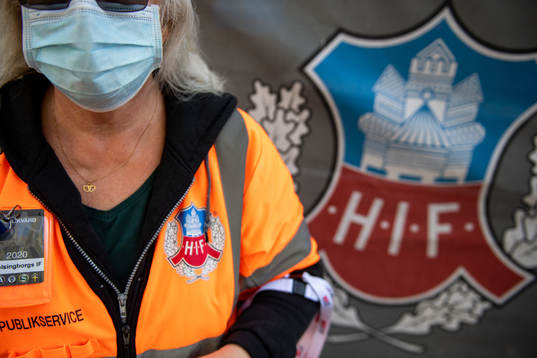 Publikvärd med ansiktsmask vid insläppet