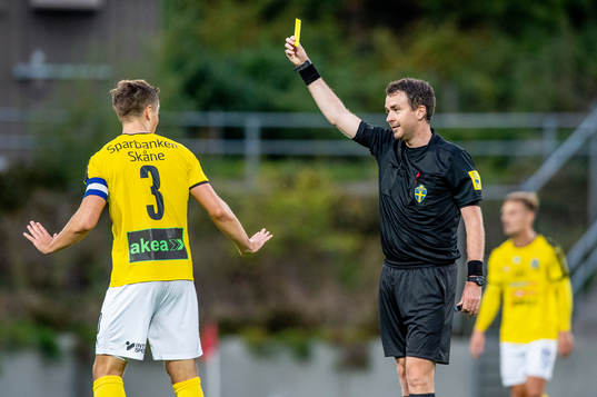 Domaren Bobby Sjögren-Engels höjer det gula kortet