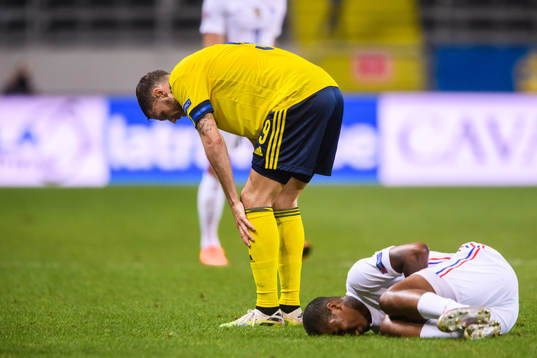 Marcus Berg of Sweden and Presnel Kimpembe of France in pain