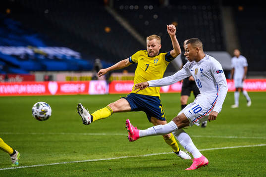 Sebastian Larsson of Sweden and Kylian Mbappé of France