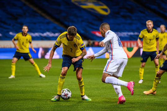 Mikael Lustig of Sweden and Kylian Mbappé of France