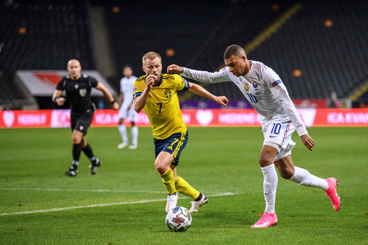 Sebastian Larsson of Sweden and Kylian Mbappé of France