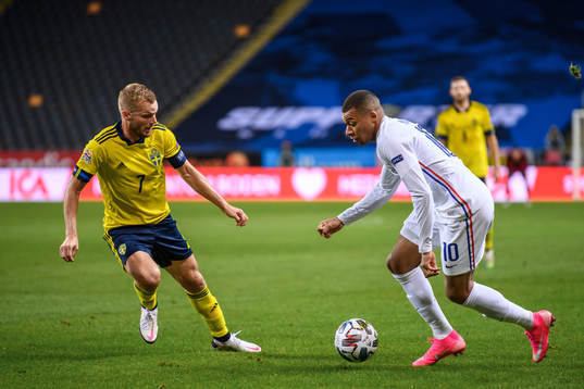 Sebastian Larsson of Sweden and Kylian Mbappé of France