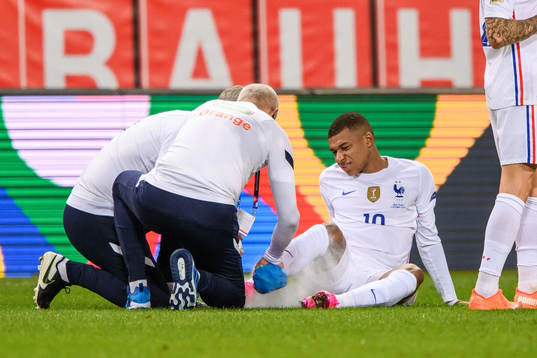 Kylian Mbappé of France receives medical attention