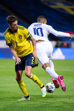 Mikael Lustig of Sweden is being dribbled by Kylian Mbappé