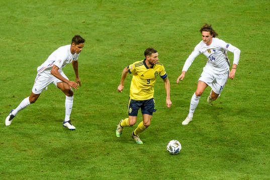Marcus Berg of Sweden against Raphaël Varane and Adrien