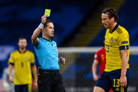 Gustav Svensson of Sweden receives a yellow card from