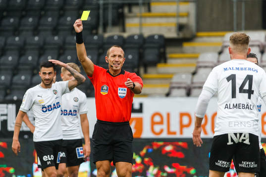 Domare Kaspar Sjöberg delar ut ett gult kort