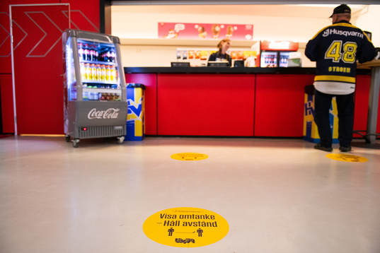 En kiosk med ett klistermärke på golvet som uppmanar