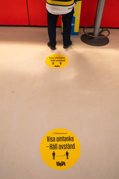 En kiosk med ett klistermärke på golvet som uppmanar