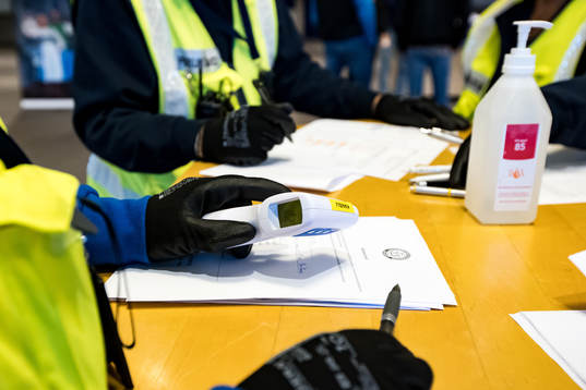 Funktionärer mäter temperaturen på åskådarna innan
