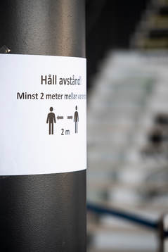 En skylt som manar till att hålla avstånd