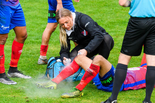 En sjukgymnast sprejar kylsprej