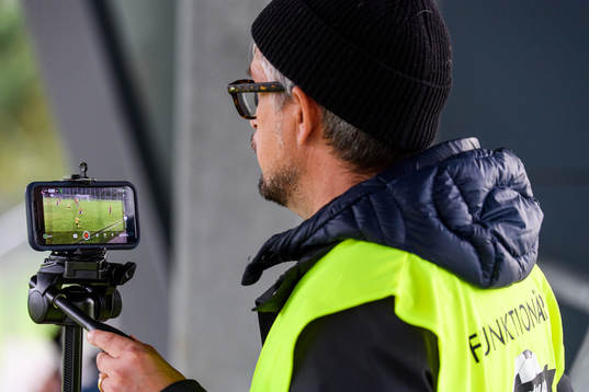 En funktionär sköter en mobiltelefon som livesänder
