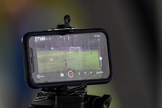 En funktionär sköter en mobiltelefon som livesänder