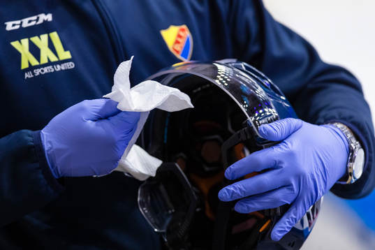 Djurgården materialare torkar plexiglaset på en hjälm
