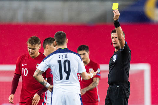 Mihailo Ristic of Serbia receives a yellow card from
