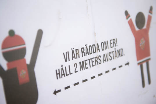 En skylt som manar till att hålla avstånd utanför
