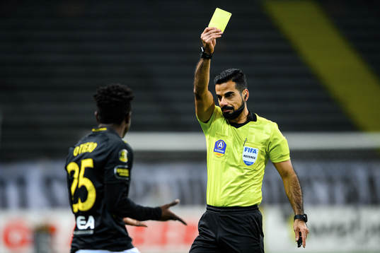 s Erick Otieno får en varning av domare Mohammed Al-Hakim
