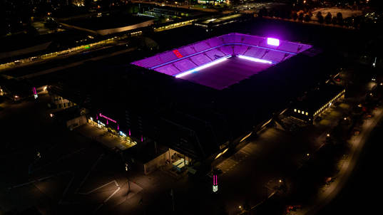 Exteriör vy över Eleda Stadion med rosa ljus på skyltar,