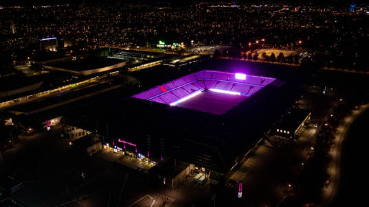 Exteriör vy över Eleda Stadion med rosa ljus på skyltar,