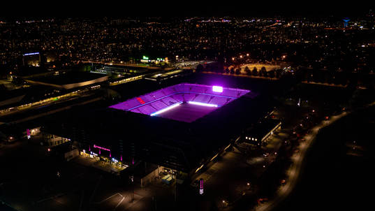 Exteriör vy över Eleda Stadion med rosa ljus på skyltar,