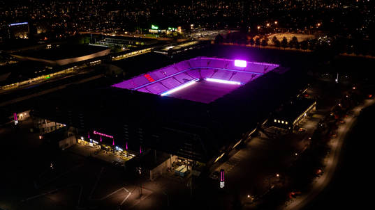 Exteriör vy över Eleda Stadion med rosa ljus på skyltar,