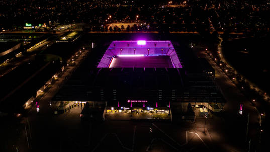 Exteriör vy över Eleda Stadion med rosa ljus på skyltar,