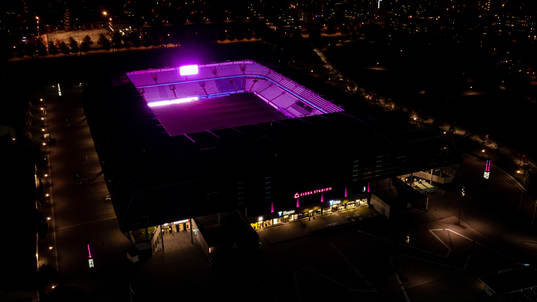 Exteriör vy över Eleda Stadion med rosa ljus på skyltar,