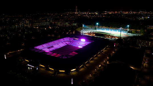 Exteriör vy över Eleda Stadion med rosa ljus på skyltar,