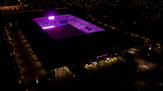 Exteriör vy över Eleda Stadion med rosa ljus på skyltar,