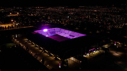 Exteriör vy över Eleda Stadion med rosa ljus på skyltar,