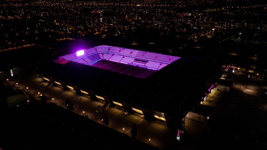 Exteriör vy över Eleda Stadion med rosa ljus på skyltar,